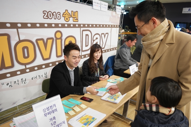 ‘무비데이’라는 이름으로 영화 송년회를 준비한 삼성전기의 권준식 경영지원실 과장이 아들과 무비데이 입장권을 받고 있다. 삼성전기 제공