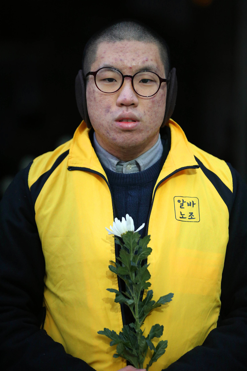 아르바이트 노동자가 국화 한 송이를 든 채 “편의점에서 죽고 싶지 않다”라고 떨리는 목소리로 말했다. 올겨울 들어 가장 추운 날씨를 보인 15일 오전 서울 강남 선릉역 한 편의점 본사 앞에서 지난 14일 경북 경산의 편의점 알바노동자가 50대 남성이 휘두른 흉기에 찔려 사망한 사건과 관련해 알바노조 편의점모임 회원들이 추모식을 열었다. 참석자들은 “알바도 안전하게 일을 할 수 있는 권리가 있다”며 차단막 설치와 비상벨 버튼 의무화 등 구체적인 해결책을 요구했다.  김봉규 선임기자 bong9@hani.co.kr