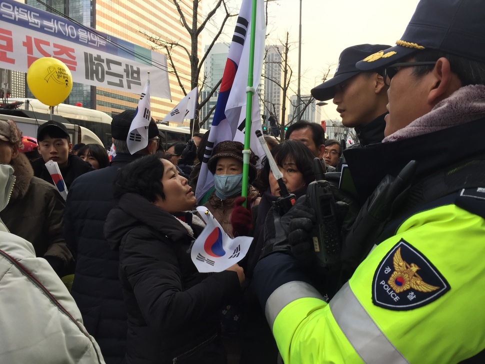 17일 8차 박근혜 퇴진 촛불집회와 탄핵 반대 극우단체가 열린 서울 광화문광장 주변에서 극우단체 회원들이 태극기를 들고 행진하고 있다. 사진 박수지 기자