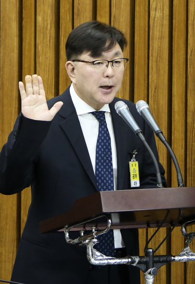 14일 열린 ‘박근혜정부 최순실 등 민간인에 의한 국정농단 의혹’ 국정조사특별위원회 제3차 청문회에서 김영재 김영재의원 원장이 대표로 증인 선서를 하고 있다. 김 원장은 증인 선서 때 손을 들지 않았다가 김성태 위원장에게 야단을 맞고 손을 들었다. <한겨레> 자료사진.