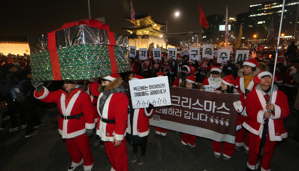 '끝까지 간다!9차 범국민행동-박근혜 정권 즉각 퇴진, 조기 탄핵, 적폐 청산 행동의 날' 집회가 성탄전야인 24일 저녁 서울 광화문광장에서 열렸다. 산타클로스 복장을 한 '박근혜정권 퇴진 청년행동' 소속 청년들이 박 대통령에게 전달할 ‘수갑선물'을 대형 상자에 담은 채 청와대 방향으로 행진하고 있다. 김정효 기자 hyopd@hani.co.kr