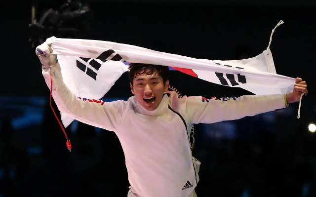 펜싱 에페 박상영이 2016 리우올림픽에서 극적인 금메달을 딴 뒤 태극기를 들고 환호하는 모습. 올림픽사진공동취재단