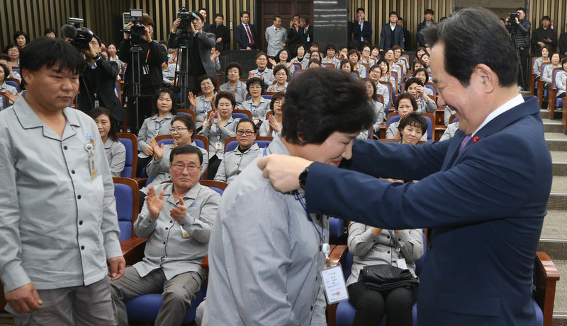 새해 들어 국회 직접고용으로 고용 형태가 바뀐 국회 환경미화 노동자들이 2일 오전 국회에서 열린 기념행사에서 정세균 의장이 동료 노동자들에게 신분증을 걸어주는 것을 지켜보며 박수치고 있다. 이정우 선임기자 woo@hani.co.kr