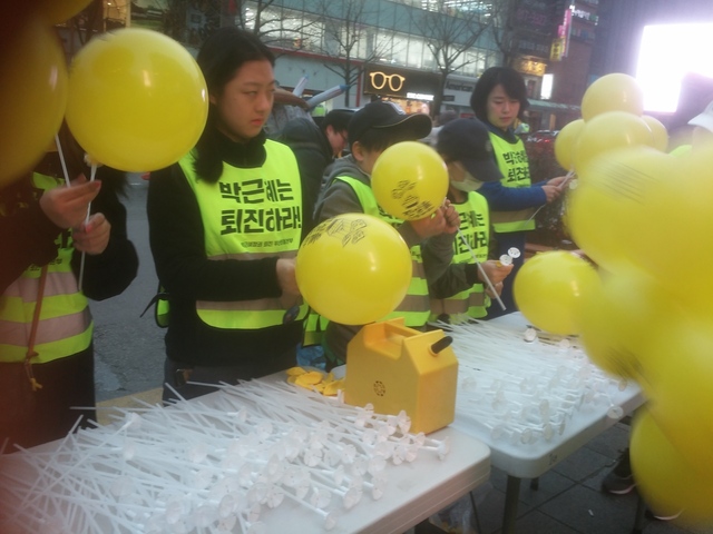 자원봉사자들이 세월호 인양을 염원하는 풍선을 시민들에게 나눠주고 있다.