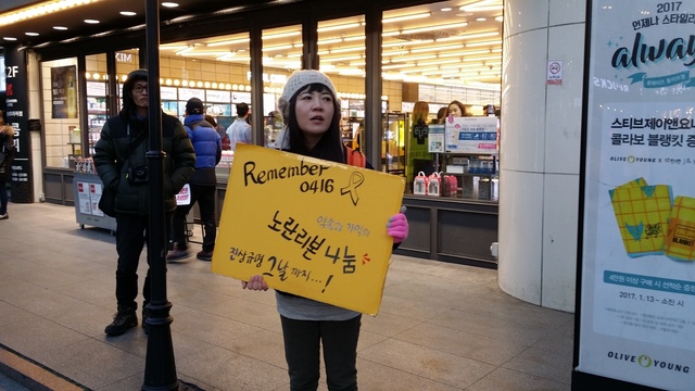 14일 부산 부산진구에서 열린 부산 촛불집회에서 한 시민이 세월호 진상규명 서명활동을 벌이고 있다.