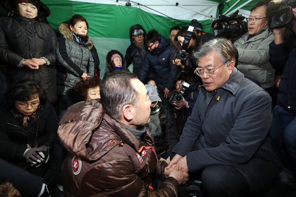 더불어민주당 문재인 전 대표(오른쪽)가 15일 밤후 전남 여수시 교동 여수수산시장 화재피해 현장을 찾아 상인을 격려하고 있다. 여수/연합뉴스.