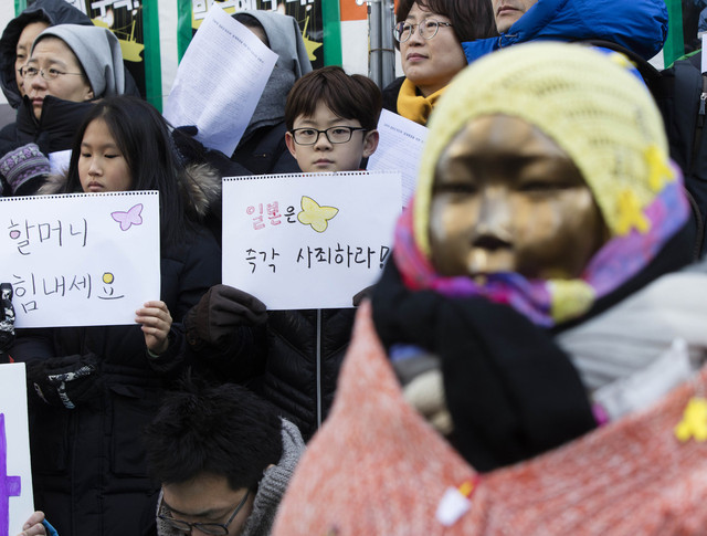 11일 서울 종로구 옛 일본대사관 앞에서 열린 1265차 일본군위안부 문제해결을 위한 정기 수요시위에 참석한 시민들이 손팻말을 들고 있다. 연합뉴스