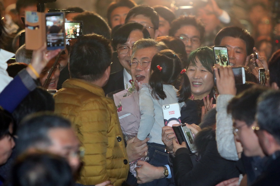 더불어민주당 문재인 전 대표(가운데)가 1월22일 오후 광주 서구 김대중컨벤션센터에서 열린 포럼광주 출범식에 입장하며 어린이 참석자를 품에 안고 있다. 포럼광주는 문 전 대표를 지지하는 모임이다.  연합뉴스