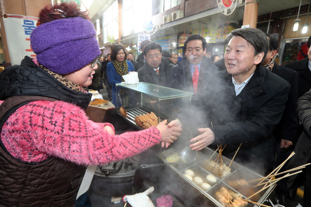 안철수 전 국민의당 대표(오른쪽)가 23일 오후 전남 목포시 목포 동부시장을 찾아 한 상인과 인사를 나누고 있다. 목포/연합뉴스