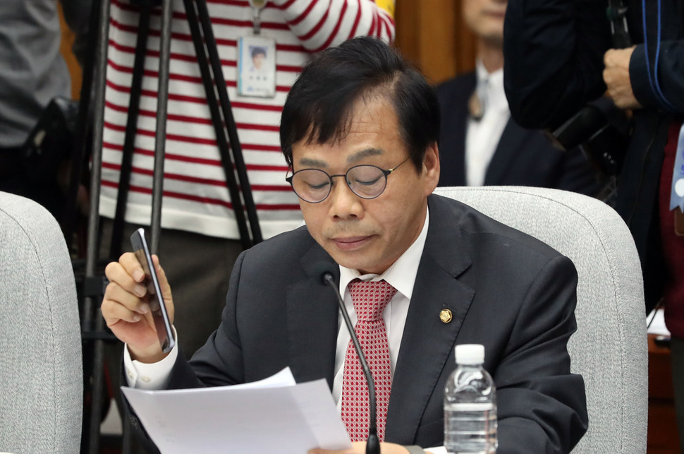 이완영 새누리당 의원이 지난해 12월14일 오전 국회에서 열린 ‘최순실 국정농단 의혹 진상규명을 위한 국정조사 특위’ 3차 청문회에서 신상발언을 하던 도중 자신에게 온 ‘18원 후원금 폭탄’ 문자를 보여주려고 휴대폰을 들어 보이고 있다. 연합뉴스
