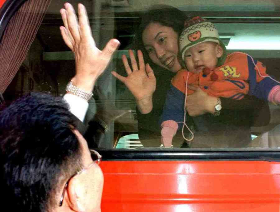 1999년 설연휴 주말을 하루 앞둔 2월 12일, 서울역과 고속버스터미널은 미리 귀성하는 사람들로 붐볐다. 직장일로 함께 귀성길에 오르지 못한 한 가장이 먼저 가는 부인과 아들에게 작별 인사를 나누고 있다. 강창광 기자