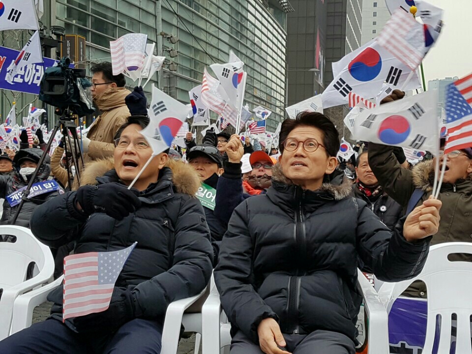 새누리당 비상대책위원인 김문수 전 경기도지사(오른쪽)와 윤상현 의원이 4일 서울 광화문 인근에서 열린 보수단체의 박근혜 대통령 탄핵반대 '태극기 집회'에 참석, 태극기를 흔들고 있다. 연합뉴스