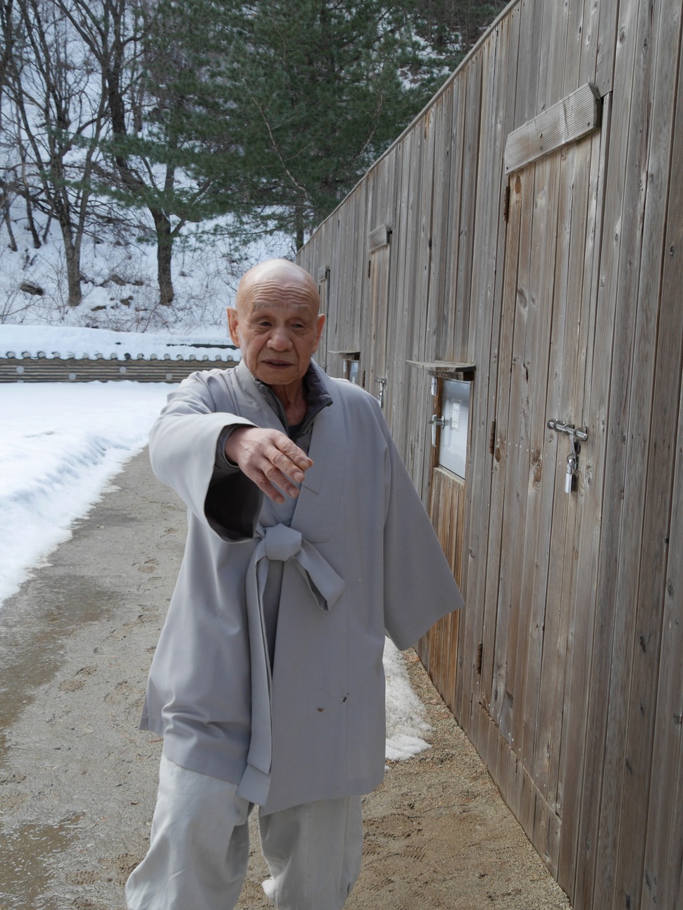 90일 독방수행을 마치고 무문관을 나서는 백담사 무금선원 조실 무산 오현 스님이 “무슨 사진이냐”며 손사래를 치고 있다. 오른쪽 문 옆에 배식구가 있다.