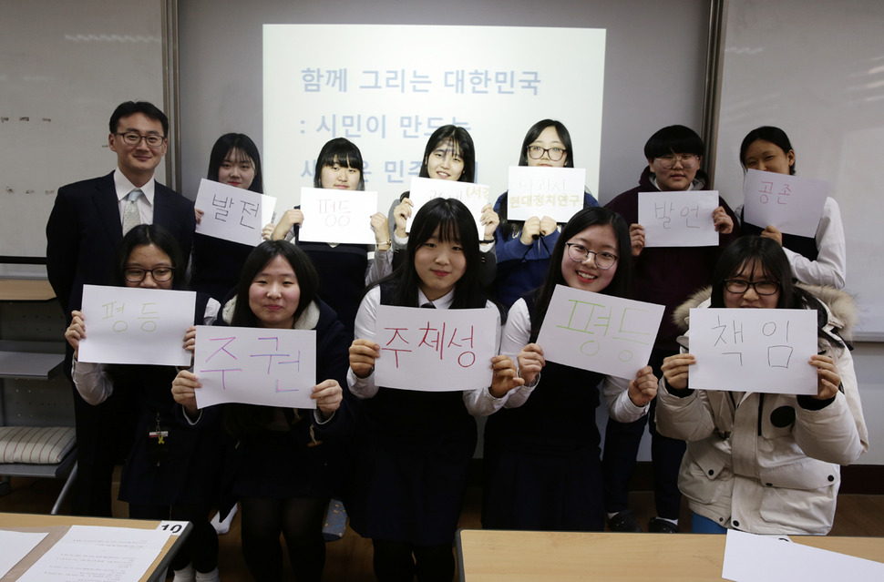 ‘나에게 민주주의는 □다.’ 6일 오후 광주광역시 북구 오치동 광주 문정여고 독서토론동아리 ‘미르나래’ 회원들이 이관후 서강대 현대정치연구소 연구원(뒷줄 맨 왼쪽)과 ‘민주주의의 미래를 말하다’라는 주제로 토론회를 마친 뒤 민주주의를 한 마디로 표현한 손팻말을 들고 있다. 광주/김명진 기자 littleprince@hani.co.kr