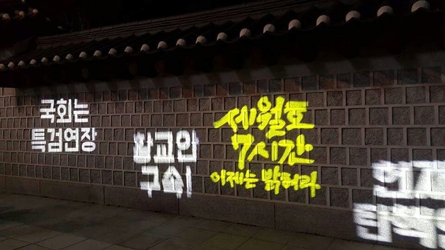 25일 서울 경복궁 담장에 ‘국회는 특검 연장, 황교안 구속! 세월호 7시간 이제는 밝혀라, 헌재는 탄핵인용’이라고 적혀 있다. 시민들이 빔으로 쏜 것이다. 김경애 기자