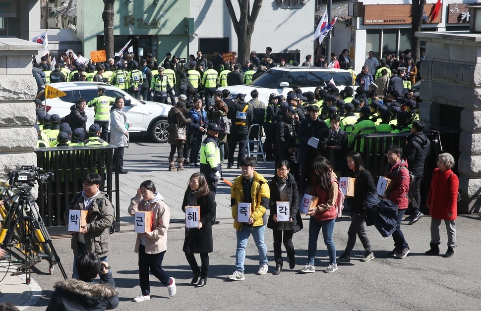 박근혜 대통령 탄핵심판 최종 변론기일인 27일 오후 서울 종로구 헌법재판소 앞에서 환경운동연합 회원들이 박 대통령 탄핵에 찬성하는 국민의 목소리를 담은 엽서 1만1986장을 들고 헌재에 제출하기 위해 들어서고 있다. 뒤로는 탄핵 무효를 주장하는 어버이연합 회원들이 농성중이다. 신소영 기자 viator@hani.co.kr