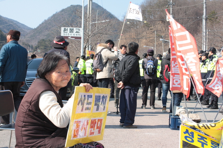 28일 오후 경북 성주군 초전면 소성리 회관 마당에서 한 할머니가 손팻말을 들고 혼자 앉아 있다.