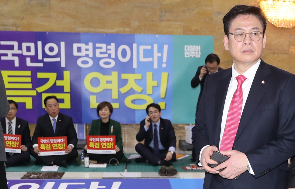 자유한국당 정우택 원내대표가 2월23일 오후 국회 본회의장 앞 더불어민주당 의원들의 특검연장 연좌 농성장 옆을 지나고 있다. 연합뉴스