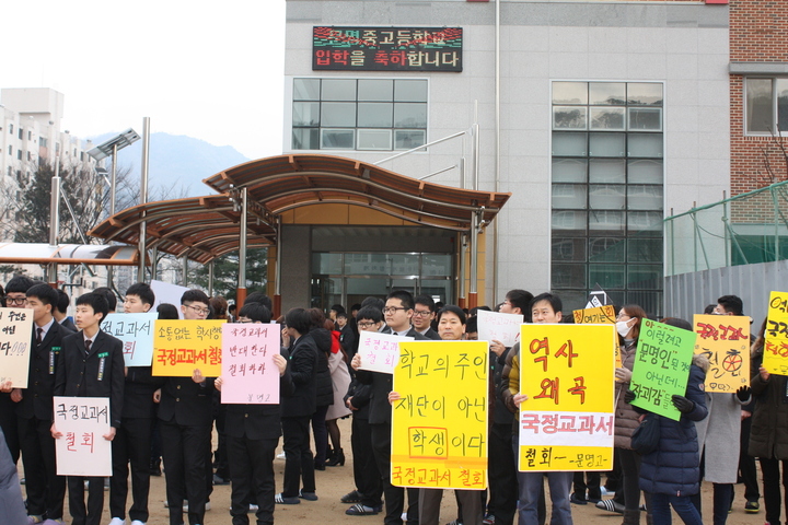 문명고 입학식이 열린 2일 오전 경북 경산시 문명고 운동장에서 학생들과 학부모들이 국정 역사교과서 연구학교 신청 철회를 요구하며 손팻말을 들고 있다.