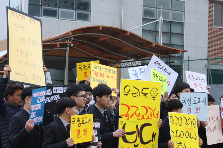 2일 오전 경북 경산시 문명고 운동장에서 1학년 학생들이 입학식이 열리는 대강당 건물 앞에서 손팻말을 들고 국정 역사교과서 철회를 요구하고 있다. 김일우 기자 cooly@hani.co.kr