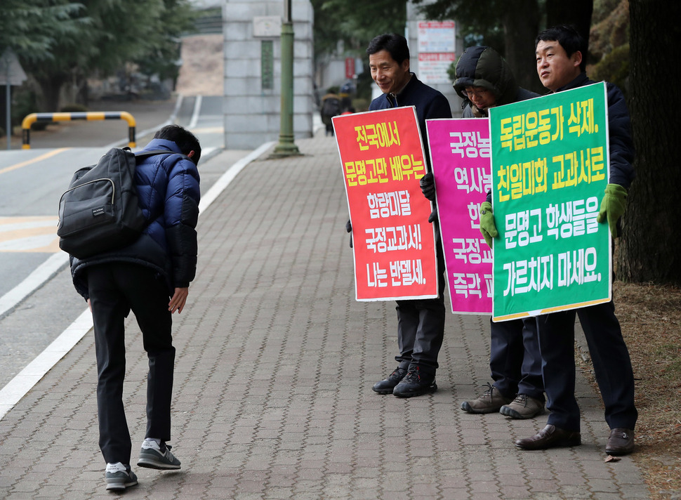 7일 오전 경북 경산시 백천동 문명고등학교 정문 앞에서 전교조 교사와 인근 주민들이 국정교과서 채택에 반대하는 내용의 손팻말을 들고 있다.  경산/연합뉴스