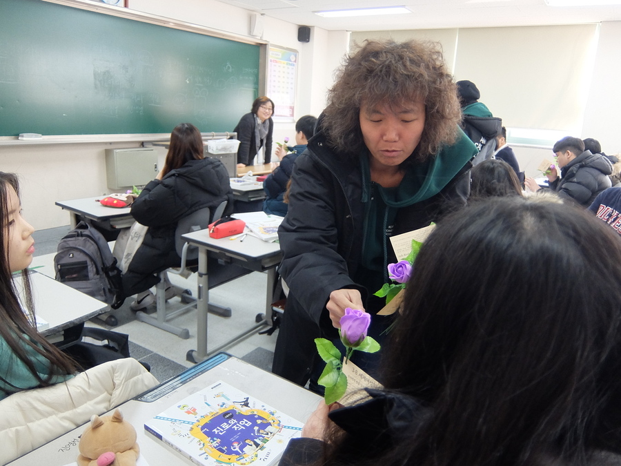 한국여성의전화 활동가가 8일 여성의날을 맞아 서울 은평구 신도고등학교 학생들에게, 이 학교 이진현 교사가 전한 보라색 꽃을 전하고 있다. 방준호 기자