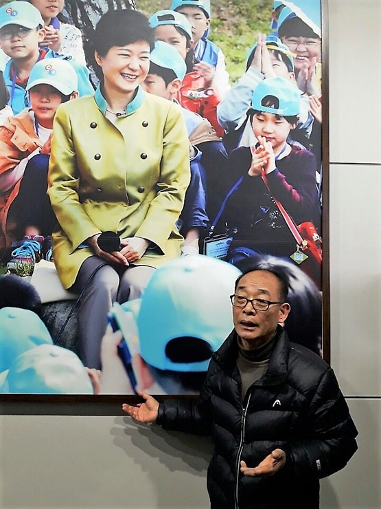 김영만 ‘박근혜 퇴진 경남운동본부’ 대표가 10일 국립3·15민주묘지 기념관 현관에 걸린 박근혜 전 대통령 사진의 문제점을 지적하며 철거를 요구하고 있다.