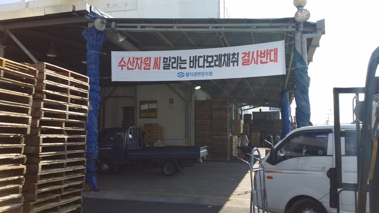 지난 8일 경남 통영시 정량동에 있는 멸치권현망수협 건물에 남해 배타적 경제수역 안 바닷모래 채취를 반대하는 내용의 펼침막이 걸려 있다. 김영동 기자