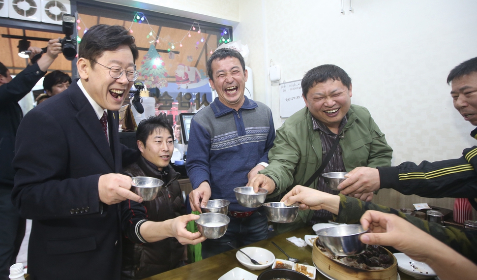 더불어민주당 대선주자인 이재명 성남시장(왼쪽)이 19일 광주 송정역 시장을 찾아 시민들과 막걸리를 마시고 있다. 광주/연합뉴스