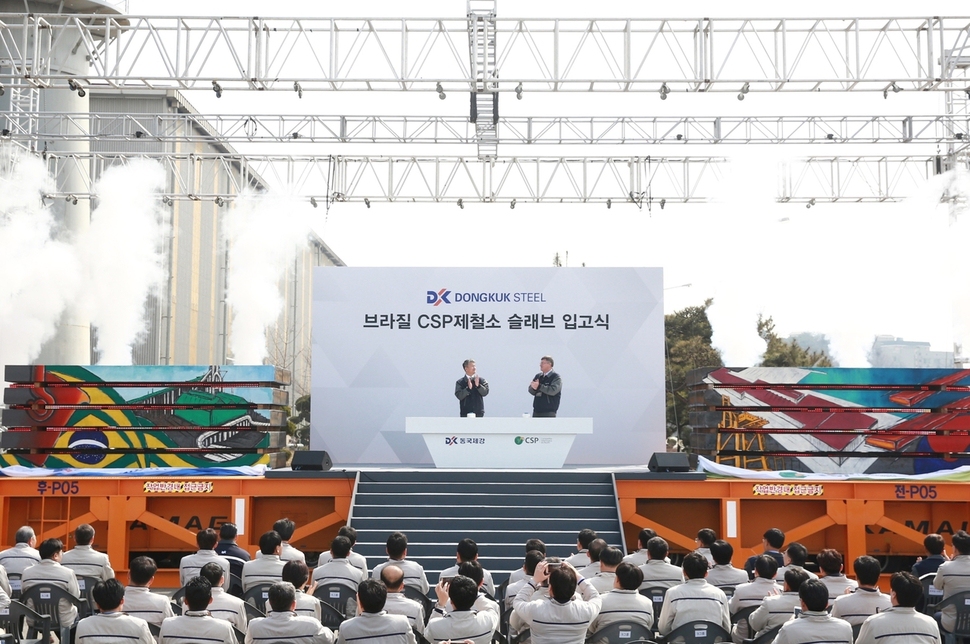 장세욱 동국제강 부회장(왼쪽)과 에두아르두 파렌치 브라질 CSP제철소 최고경영자(CEO)가 22일 충남 당진의 동국제강 공장에서 박수를 치며 슬래브 입고를 축하하고 있다. 동국제강 제공
