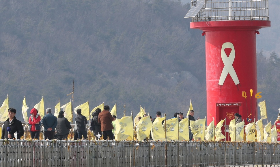 세월호가 물 위로 그 모습을 드러낸 23일 오후 전남 진도군 임회면 팽목항 방파제를 찾은 시민들이 먼바다를 바라보고 있다. 연합뉴스 