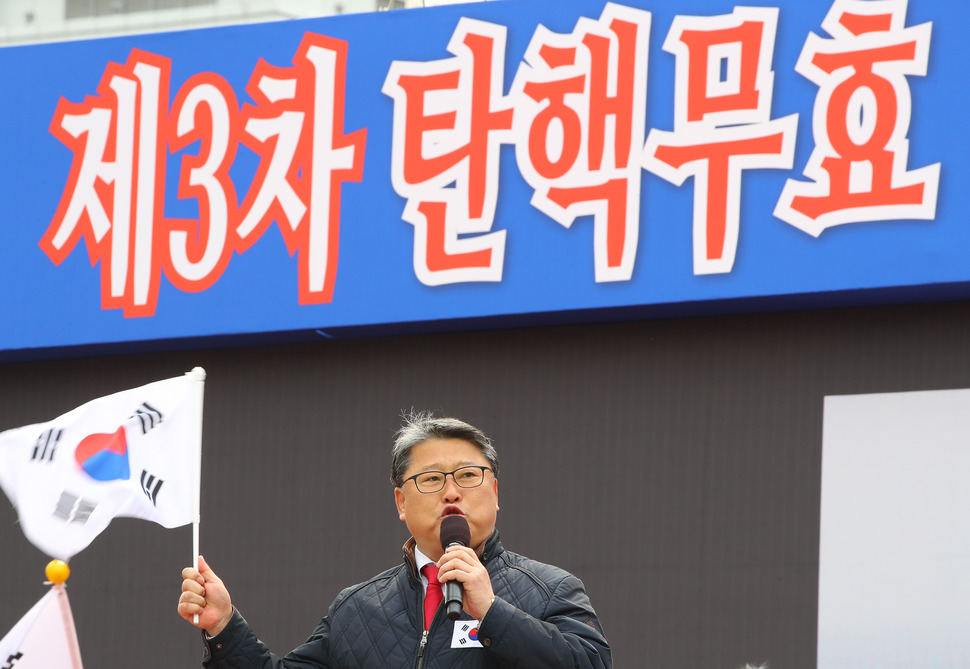 자유한국당 조원진 의원이 25일 오후 서울 시청 광장에서 열린 탄핵 국민저항본부 집회에 참석해 태극기를 들고 ‘‘탄핵 무효‘‘와 관련한 발언을 하고 있다. 연합뉴스