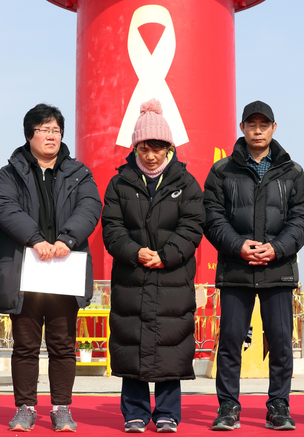 세월호 미수습자 가족들이 28일 오전 전남 진도군 팽목항에서 세월호 선체조사위원들에게 공식 면담을 요청하는 등의 기자회견을 진행하며 세월호의 목포 신항 무사 이동을 기원하며 두 손을 꼭 쥐고 있다. 연합뉴스