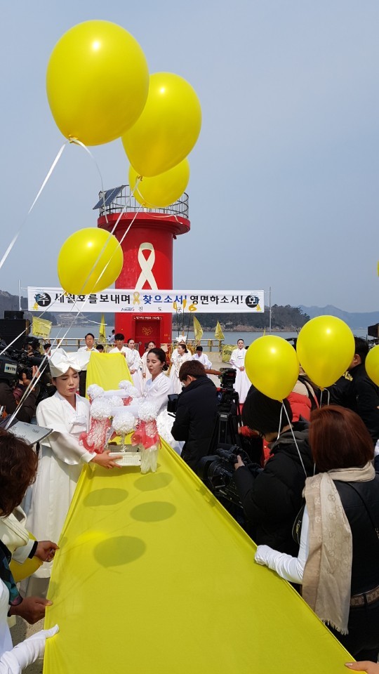 진도군립민속예술단원들이 28일 오전 팽목항 방파제에서 세월호를 상징하는 노란 천 위에서 희생자들에게 길을 닦아주는 공연을 펼치고 있다.