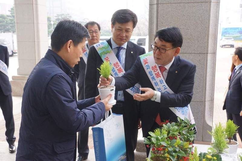 울산시와 농협 울산지역본부는 29일 아침 울산시청 현관에서 출근하는 공무원들에게 꽃 화분을 하나씩 나눠주며 지역 화훼농가를 돕기 위한 ‘꽃 문화 정착’ 캠페인을 벌였다. 농협 울산지역본부 제공
