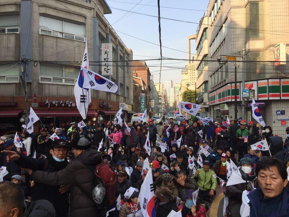 30일 아침 서울 강남구 삼성동 박근혜 전 대통령 자택 앞에서 지지자들이 태극기를 흔들고 있다. 김규남 기자