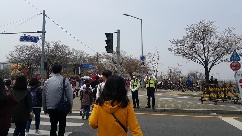 8일 낮 서울 여의도 봄꽃축제 현장에서 경찰관이 마스크를 쓴 채 교통정리를 하고 있다. 황금비 기자