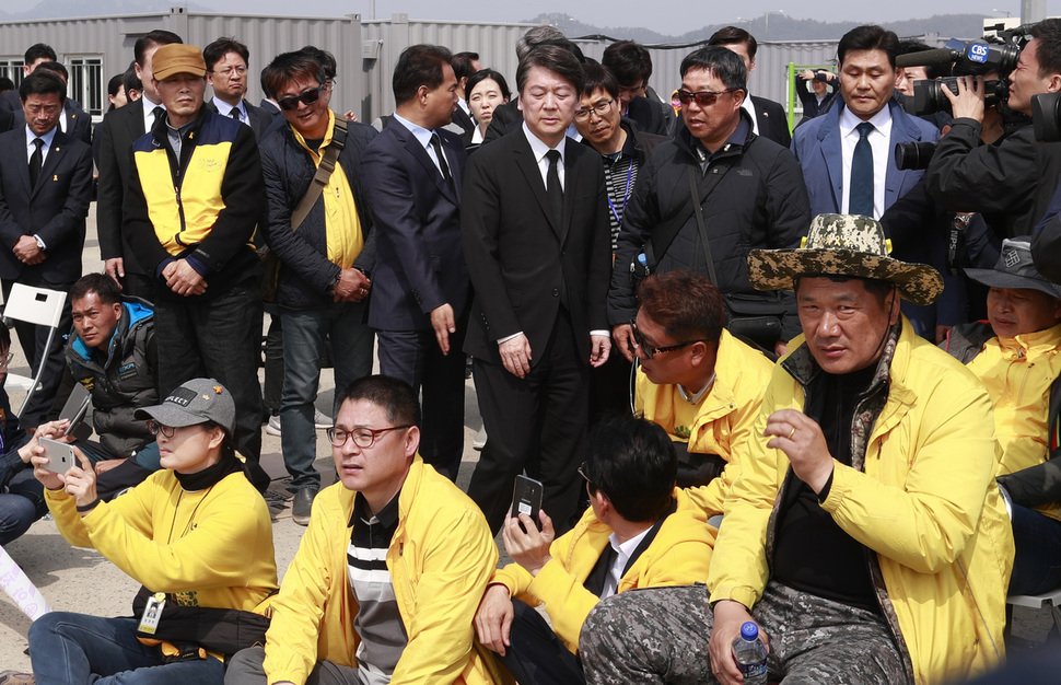 9일 오후 세월호가 있는 목포신항을 찾은 안철수 국민의당 대선 후보가 자신을 등지고 돌아앉은 유가족의 곁을 지나고 있다. 유가족들은 지난 7일 목포신항을 방문한 국민의당 목포시의원 등 일부 당 관계자들이 세월호를 배경으로 기념사진을 찍은 데 대해 항의한 바 있다. 목포/공동취재사진