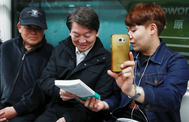 안철수 국민의당 대선후보가 5일 오전 지하철에서 만난 한 청년에게 책을 선물받고 있다. 연합뉴스