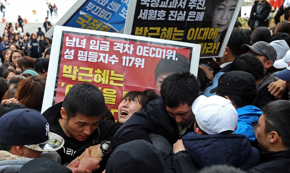 박근혜 전 대통령이 제50회 전국여성대회에 참석차 이화여대를 방문한 것에 항의하는 학생들이 행사장으로 가다 사복경찰에게 제지 당하자 한 학생이 울음을 터뜨리고 있다. 팻말에는 “박근혜는 ‘여성’을 말할 자격이 없다”고 적혀 있다. 이정용 선임기자 lee312@hani.co.kr