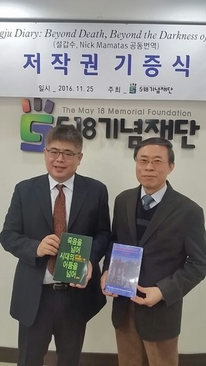 지난 25일 5·18기념재단에서 열린 <죽음을 넘어 시대의 어둠을 넘어> 영문판 저작권 기증식에서 원저자인 이재의(오른쪽) 박사와 영문판 역자 설갑수씨가 국·영문판 책을 바꿔 든 채 함께 했다.