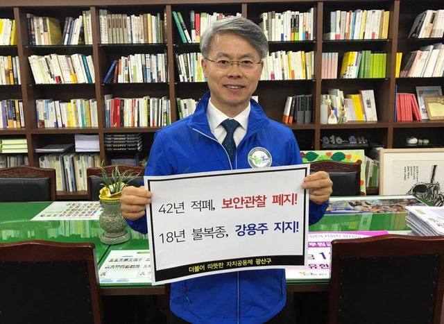 강용주씨의 보안관찰법 불복종 운동에 참여하자고 제안한 민형배 광주광산구청장이 지난 21일 청장실에서 팻말을 들고 있다. 페이스북 갈무리