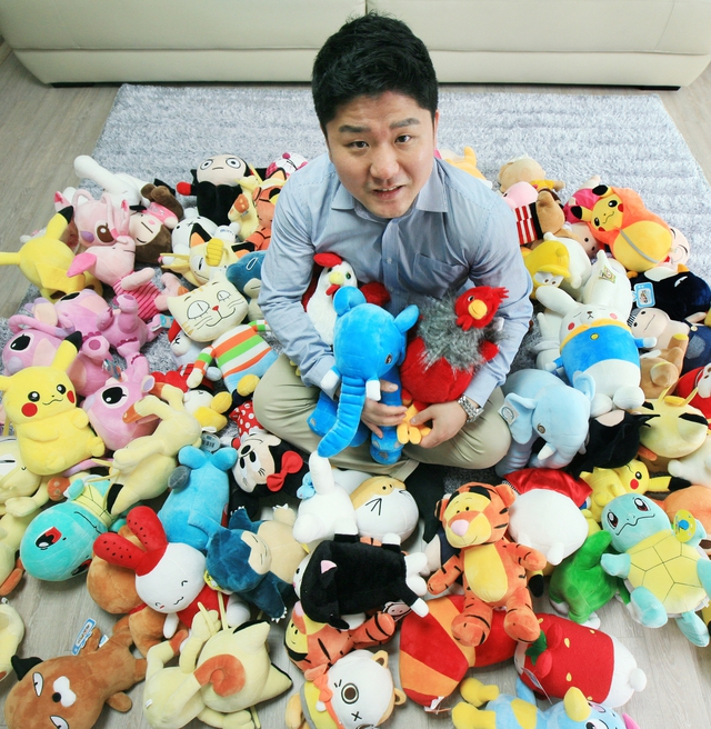 인형뽑기 고수 이재목씨가 인형 위에서 활짝 웃고 있다. 사진 이정국 기자