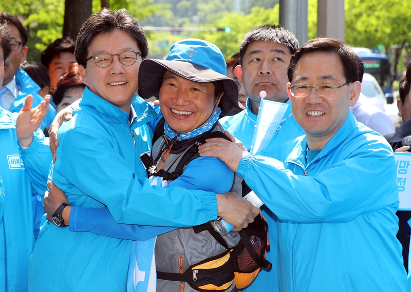 유승민 바른정당 대통령 후보(맨 왼쪽)가 27일 오전 대구 수성구 담티역에서 ’새로운 보수’를 알리며 국토대장정 중인 이학재 의원(가운데)을 만나 포옹하고 있다. 대구/연합뉴스