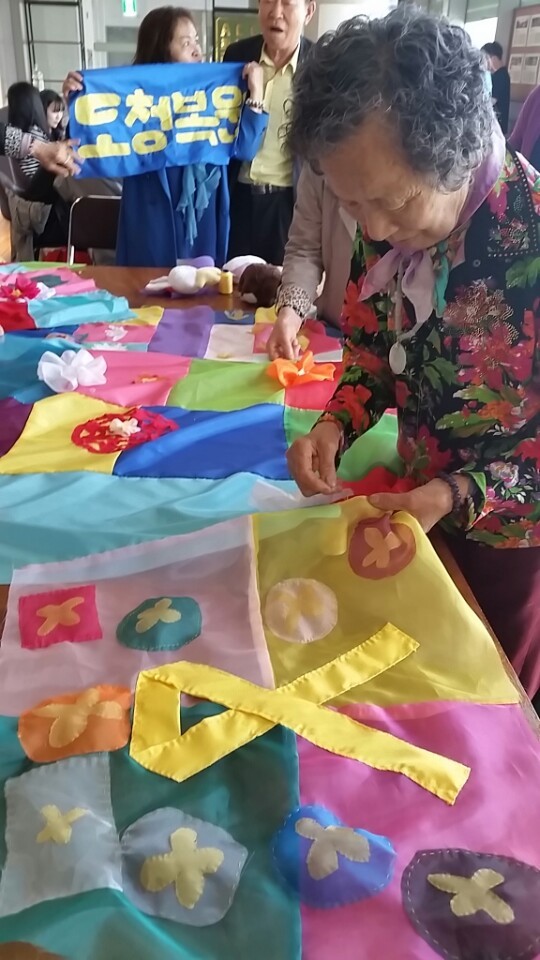 박순금(78)씨가 29일 세월호 유가족 어머니가 만든 조각보를 오월 어머니들이 만든 조각보를 잇기 위해 바느질을 하고 있다. 정대하 기자