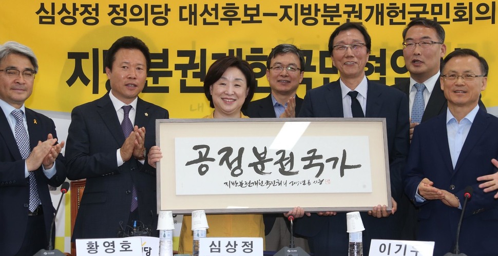 심상정 정의당 대통령 후보(가운데)가 2일 오전 국회에서 지방분권개헌국민행동 이기우 상임대표(오른쪽 셋째) 등 대표자들과 지방분권 개헌 협약서에 서명한 뒤 `공정분권국가'라고 적힌 글귀를 선물받고 있다. 이정우 선임기자 woo@hani.co.kr