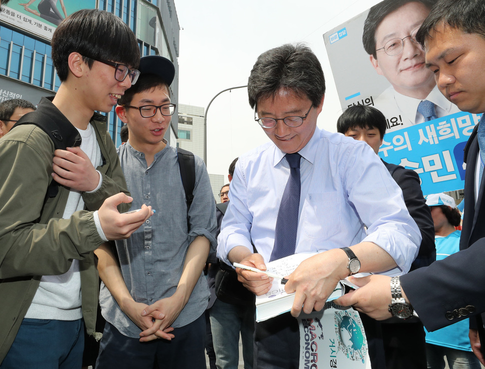 유승민 바른정당 대통령 후보가 4일 낮 서울 서대문구 신촌에서 한 학생이 내민 경제학 서적에 사인을 해주고 있다. 김태형 기자 xogud555@hani.co.kr