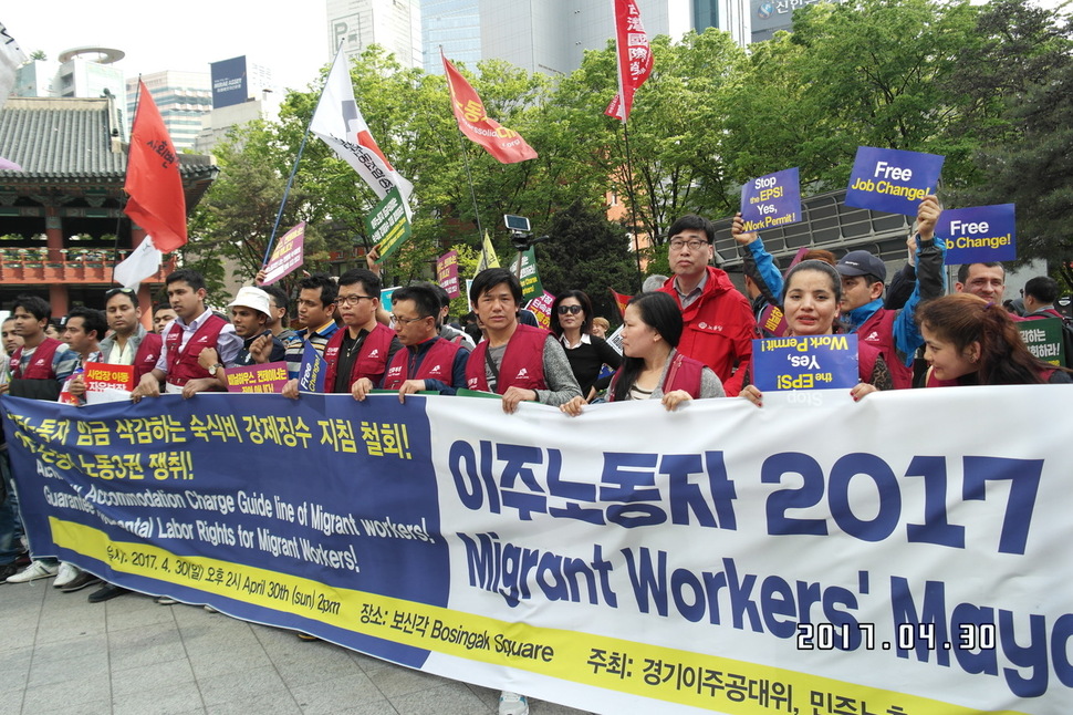 지난달 30일 서울 종로 보신각 근처에서 열린 이주노동자 집회에서 참가자들이 노동3권 쟁취 등의 요구사항이 적힌 펼침막을 들고 서 있다. 조일준 기자