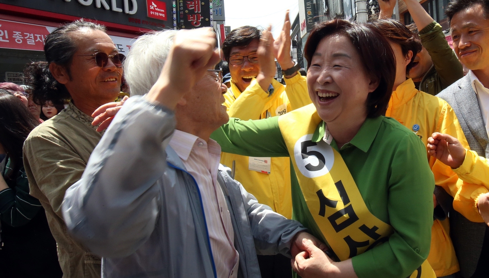 정의당 심상정 대선후보가 7일 오전 청주시 성안길에서 열린 유세에서 한 시민의 응원을 받고 환하게 웃고 있다. 연합뉴스