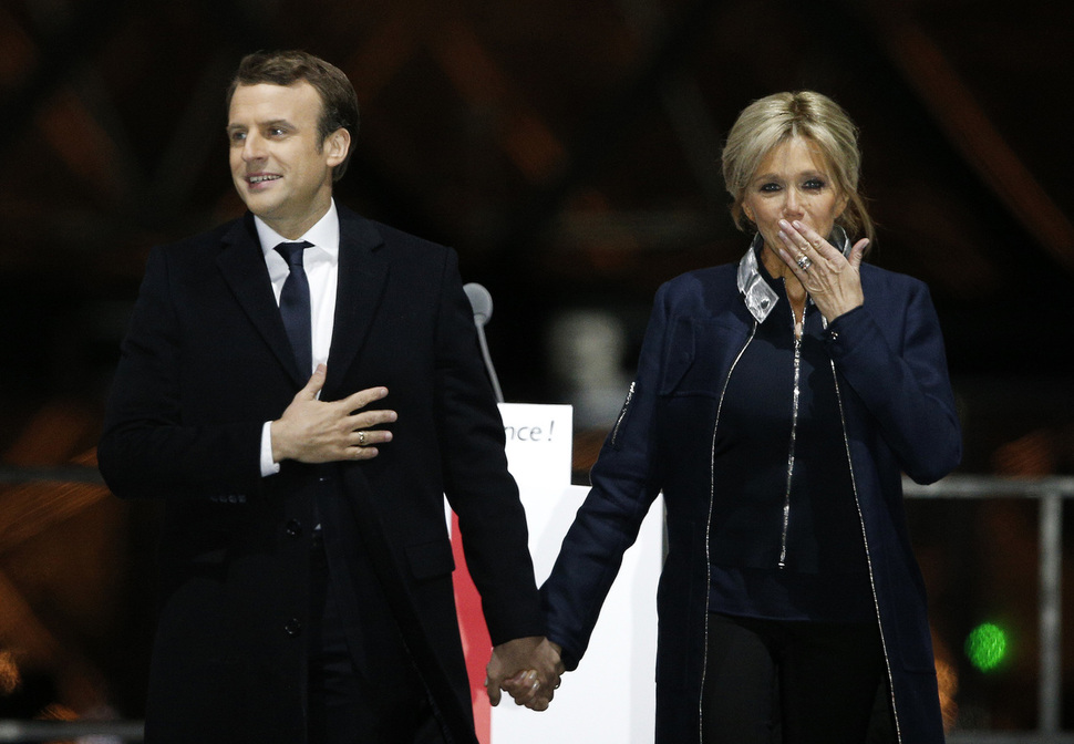 에마뉘엘 마크롱(39) 프랑스 대통령 당선자(왼쪽)가 7일 밤(현지시간) 파리 루브르박물관 앞에서 25살 연상의 아내 브리지트 트로뇌와 함께 당선 확정 뒤 지지자들에게 감사 인사를 보내고 있다.     파리/연합뉴스